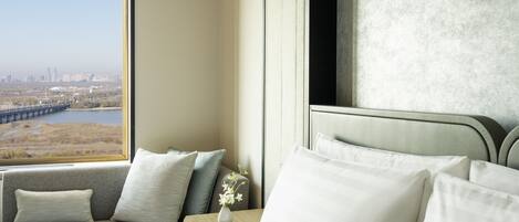 A hotel room with a large window offering a view of a bridge and cityscape.