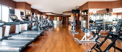 A gym with treadmills, elliptical machines, and weight equipment.