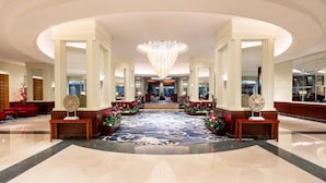 A spacious lobby with a grand chandelier, a central floral arrangement, and a reception desk. - Shangri-La Harbin (Harbin)