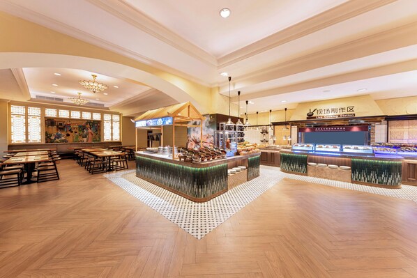 A spacious dining area with wooden tables and a central island with a food display.