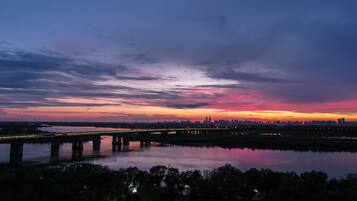 Atardecer sobre el horizonte de una ciudad con un puente cruzando un cuerpo de agua.