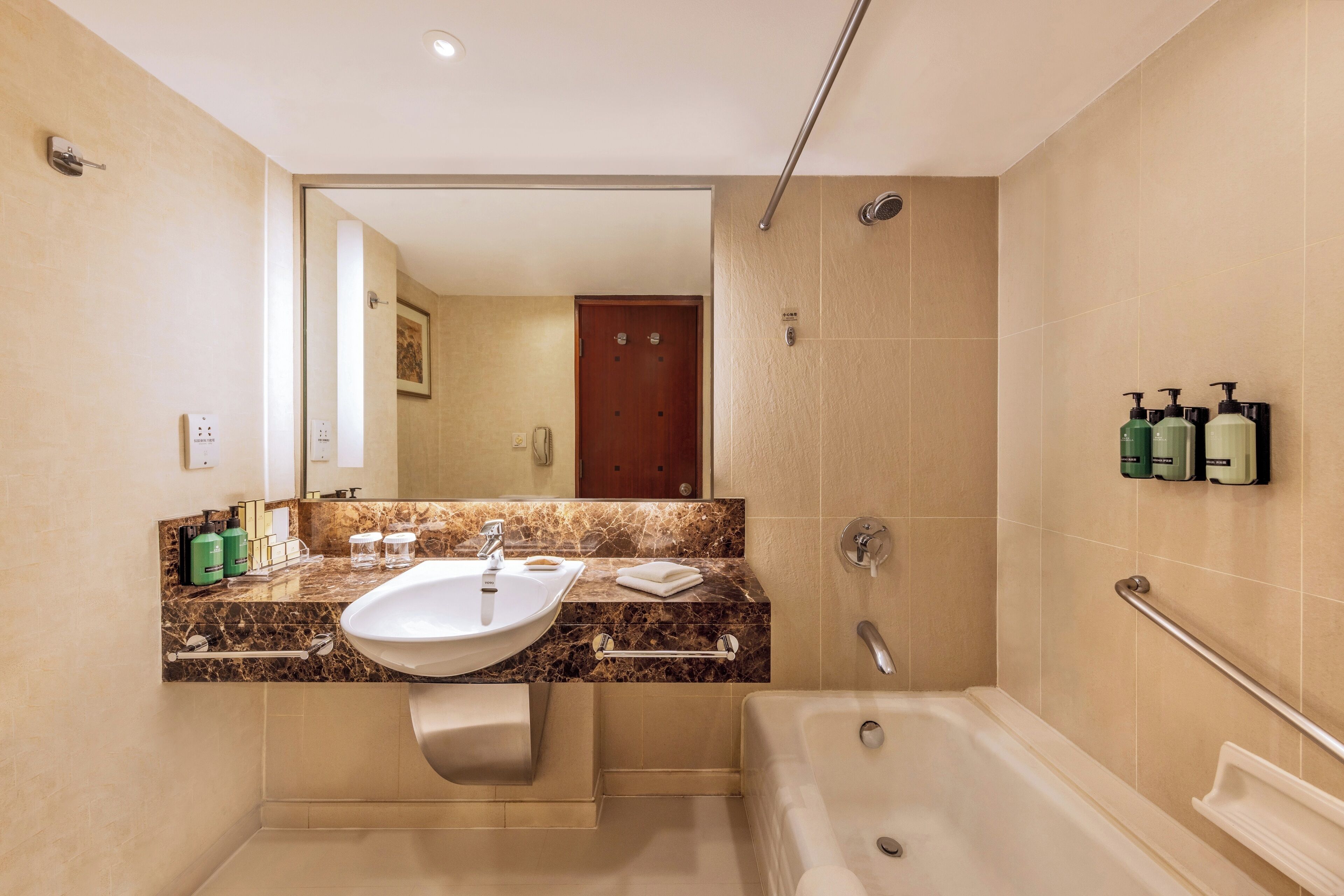 A modern bathroom with a marble countertop, a sink, a bathtub, and a shower.