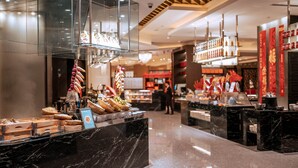 A modern hotel lobby with marble countertops, a buffet area, and a seating area.