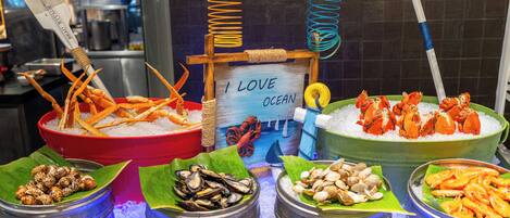 Una exhibición de mariscos con diversos crustáceos y pescados sobre hielo, incluyendo camarones y mejillones.