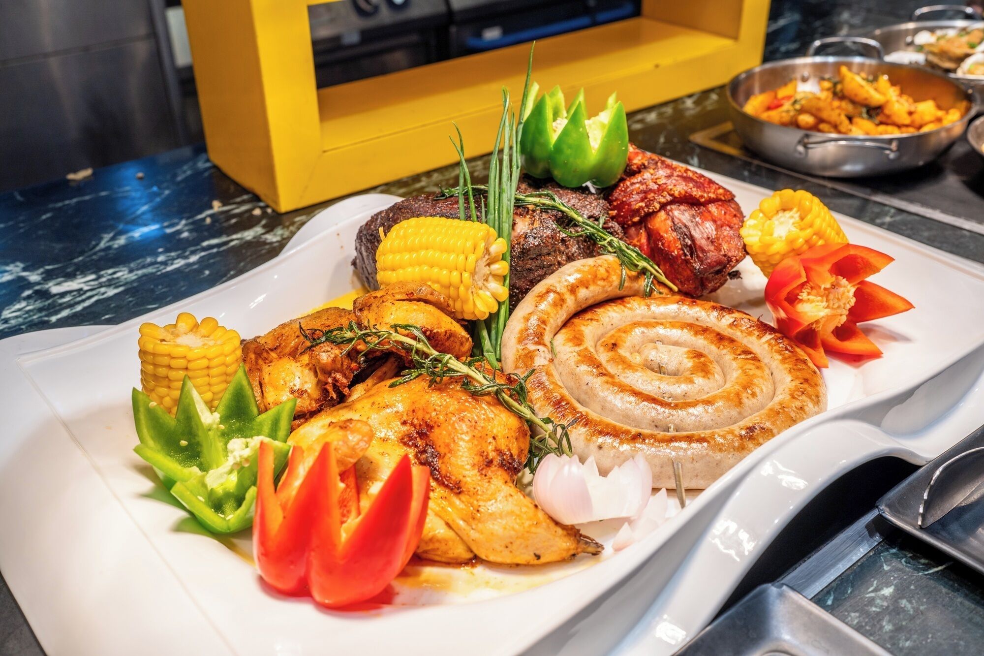 A plate of grilled meats, vegetables, and a sausage.