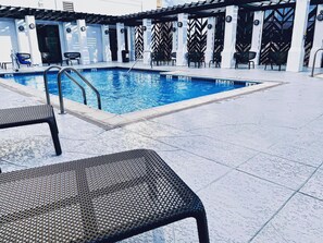 室外游泳池，開放時間為 10:00 至 22:00，提供日光浴躺椅