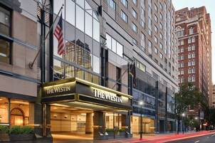 A hotel with a prominent entrance, large windows, and an American flag.