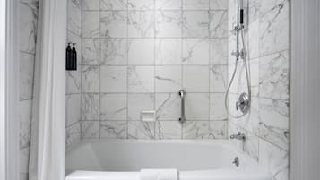 Une salle de bain moderne avec une douche carrelée en marbre et une baignoire.