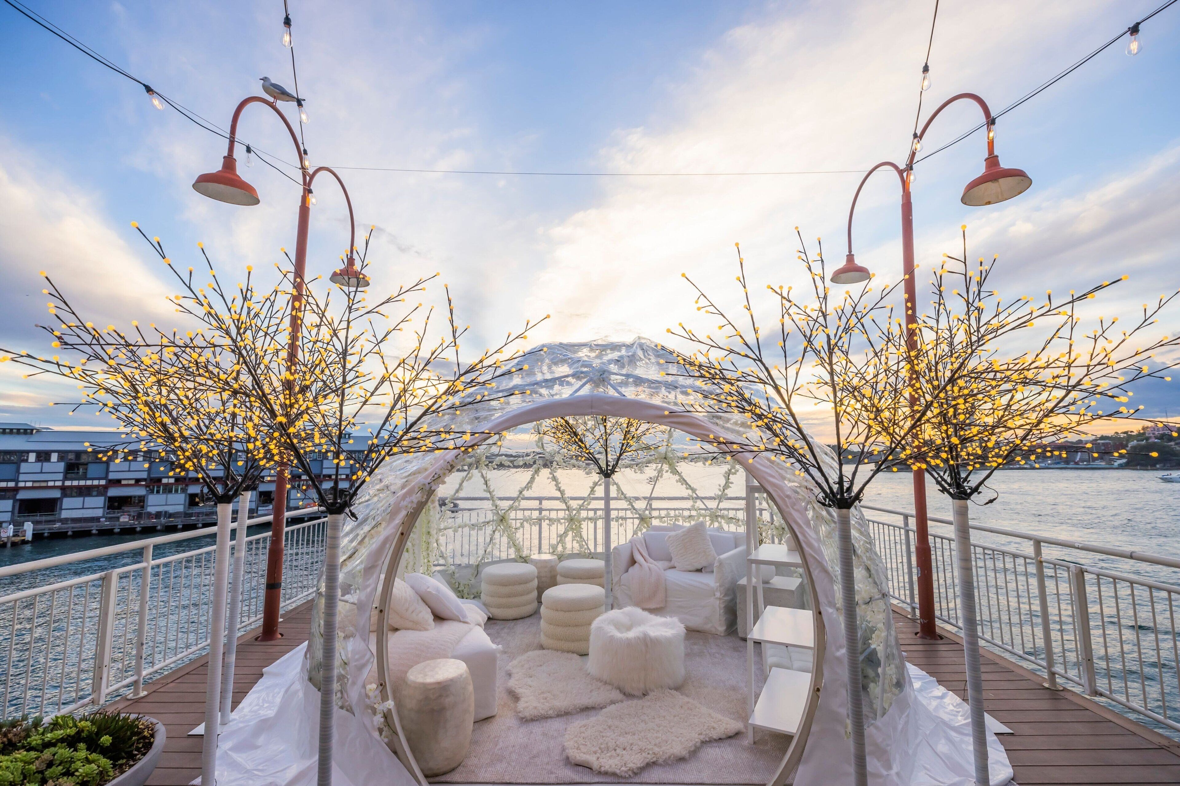 A covered seating area with white furniture and a view of the river.