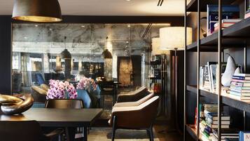 A modern dining area with a table, chairs, and a vase of flowers.