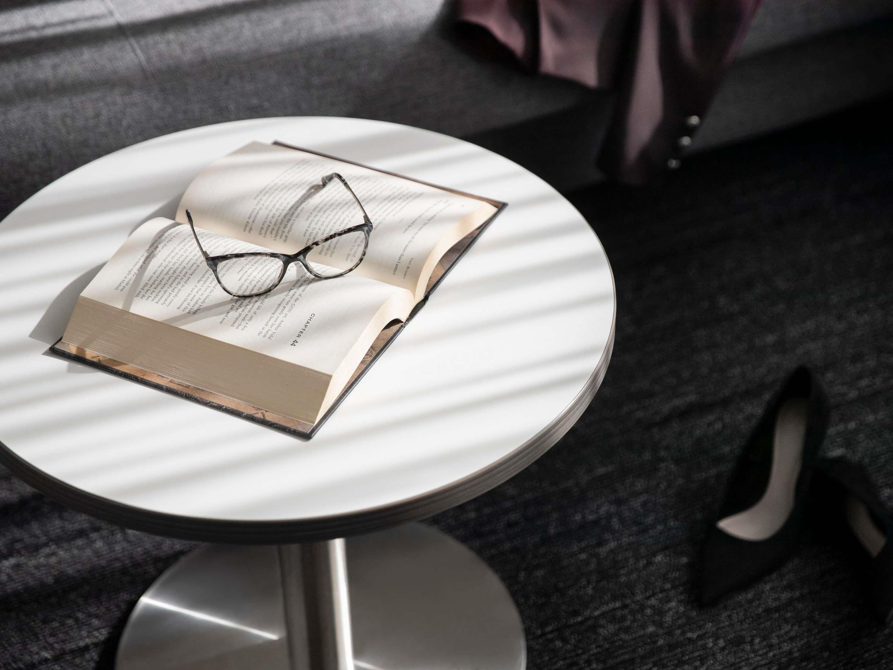 A round table with a book and glasses on it.