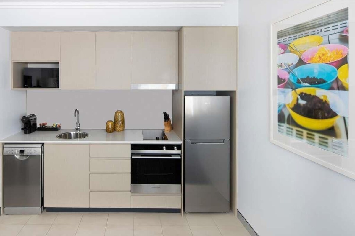 A modern kitchen with stainless steel appliances, a dishwasher, and a sink.