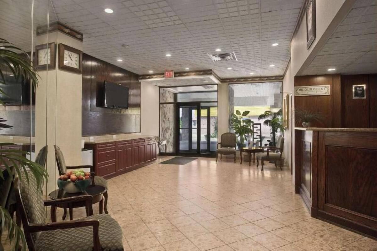 Un hall con mostrador de recepción, zona de estar y un reloj en la pared.