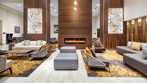 Una sala de estar moderna con chimenea, sofás y una alfombra estampada.