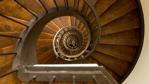 A spiral staircase with wooden steps and metal railings. - AC Hotel Mainz (Mainz)