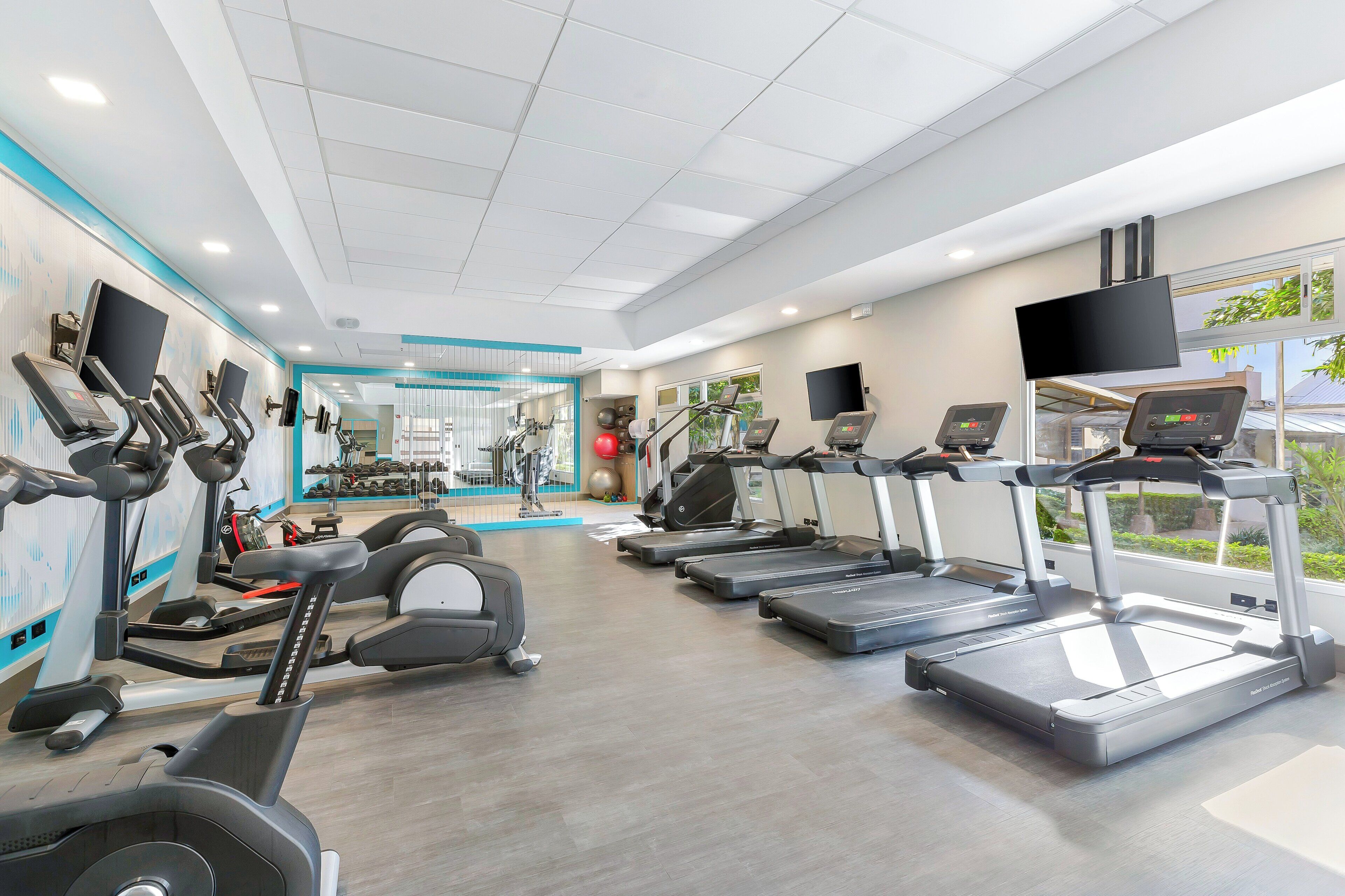 A gym with multiple treadmills, stationary bikes, and weight machines.
