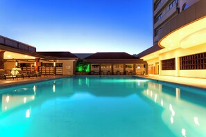 Una piscina con sillones de descanso y un edificio con un letrero que dice 'Salone'.