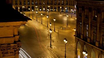 Un'ampia piazza aperta, con lampioni disposti regolarmente e un grande edificio a fondo con architettura classica.
