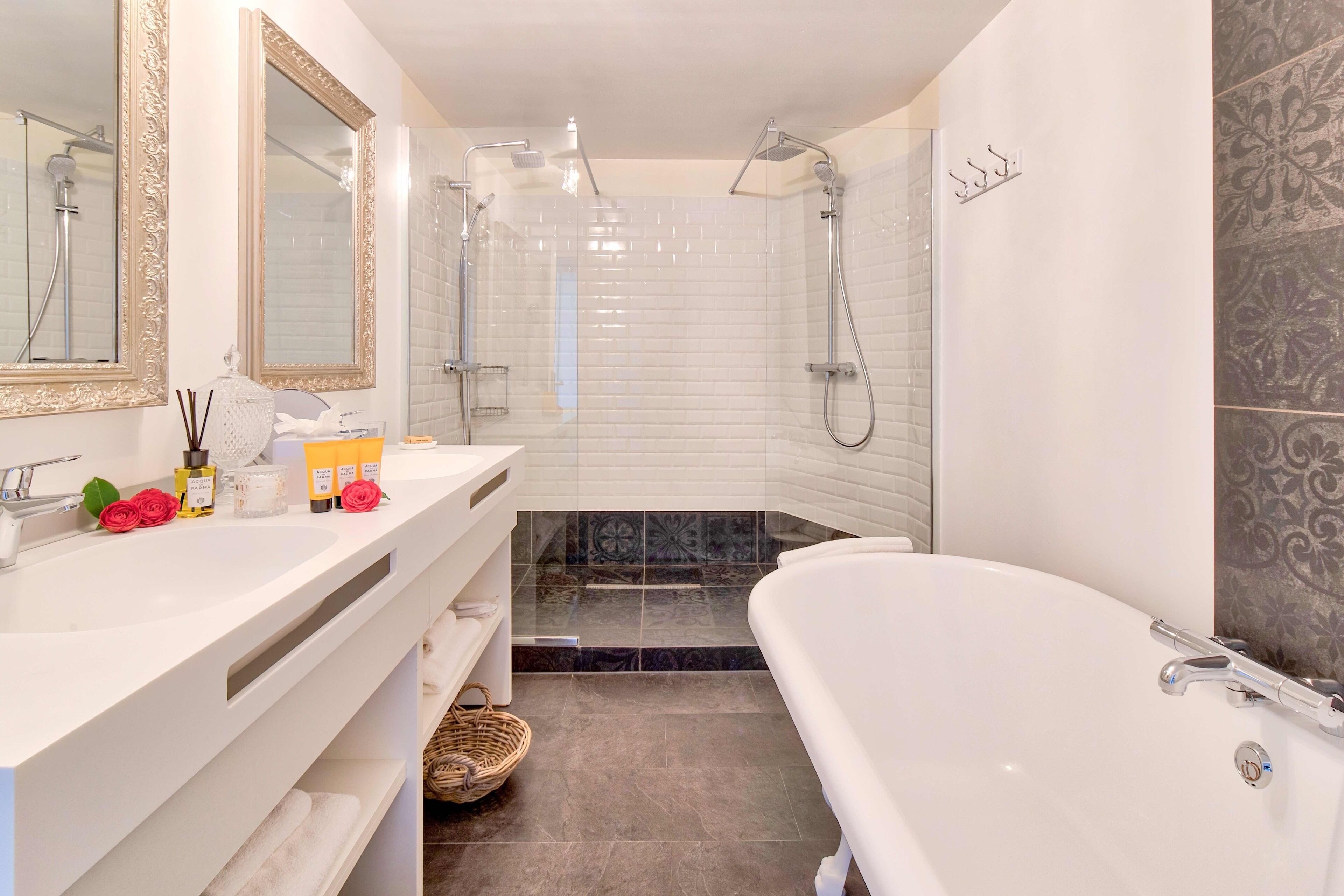 A modern bathroom with a white sink, large mirror, and a freestanding bathtub.