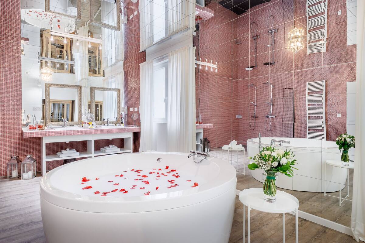A modern bathroom with a large bathtub, a white vanity, and a shower area.