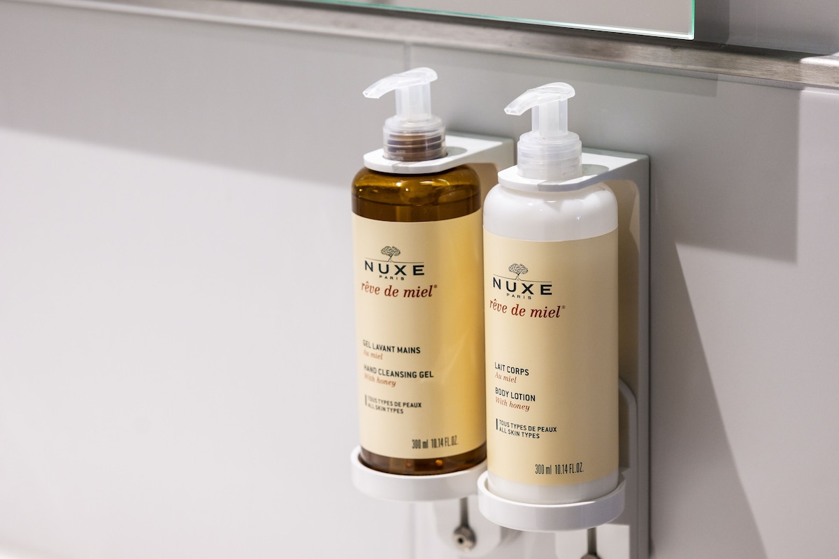 Two Nuxe body care products mounted on a wall.