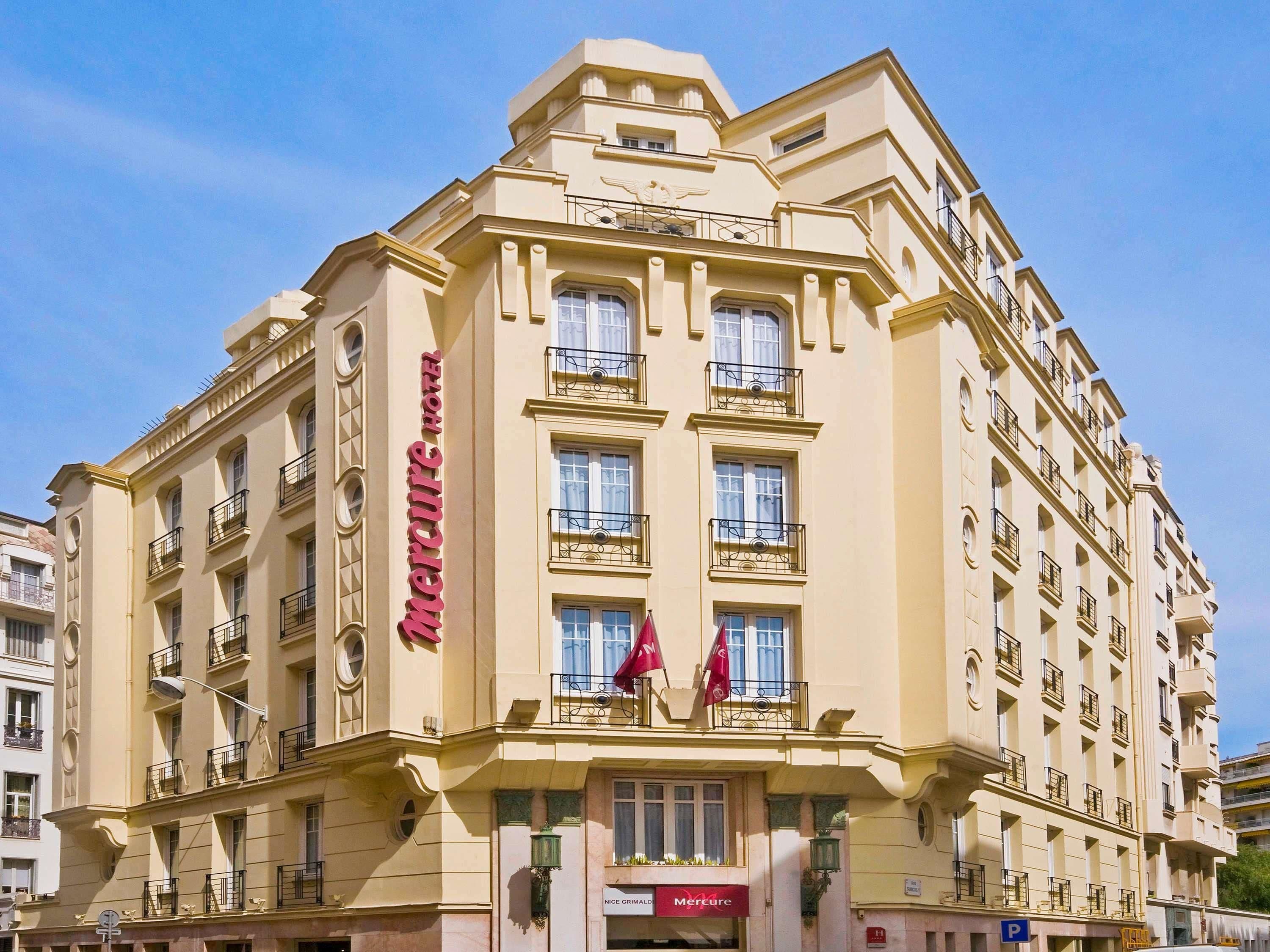 A corner building with a Mercure hotel sign, multiple balconies, and a visible entrance with a sign for 'Nice Grimaldi.'