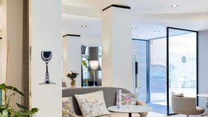 Una sala de estar moderna con un sofá, sillones, una mesa de centro y un ventanal de vidrio que da al exterior.