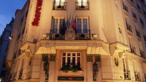 Un edificio histórico con una entrada imponente, varios balcones y un letrero destacado.