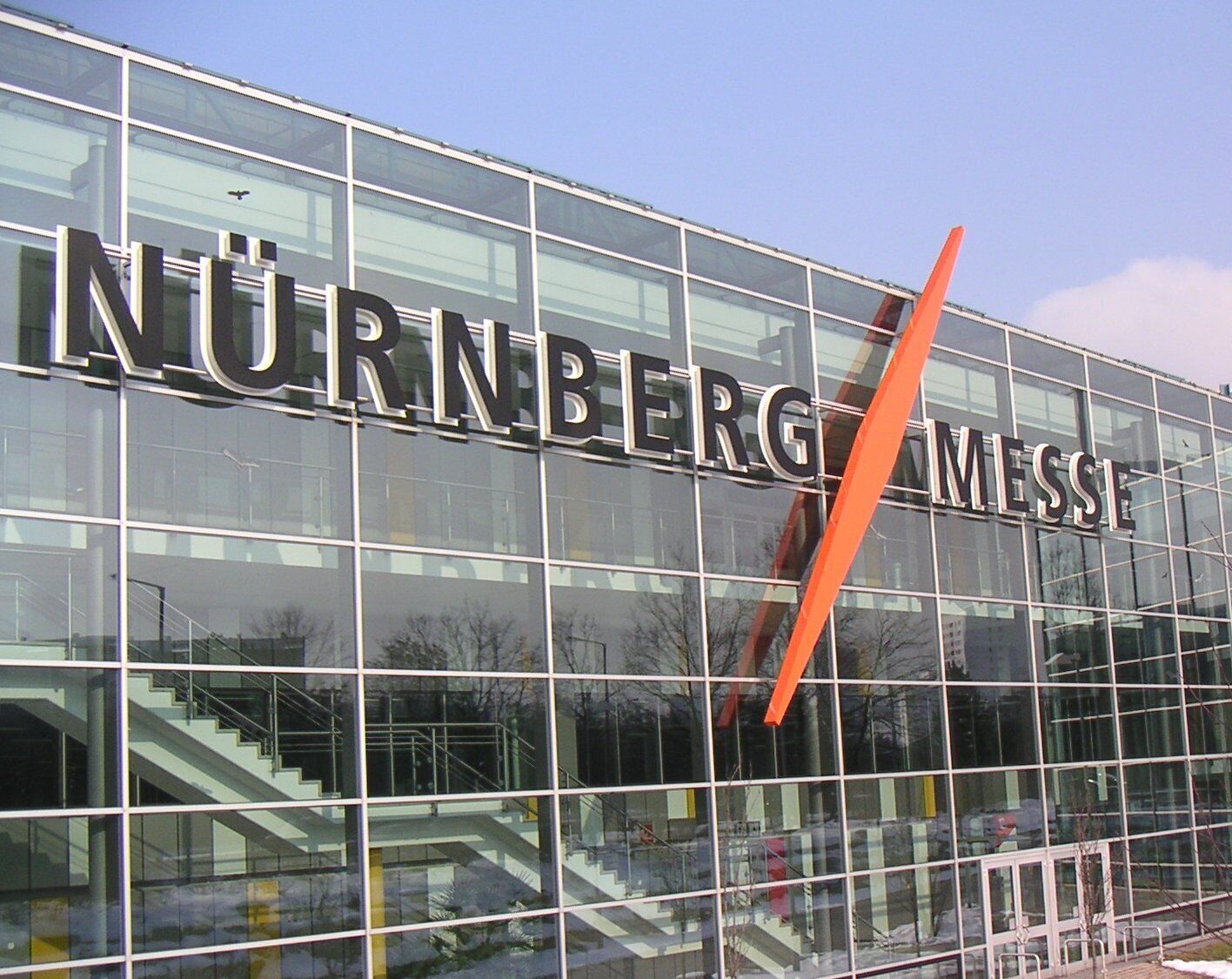 Ein modernes Gebäude, auf dessen Fassade der Schriftzug "NÜRNBERG MESSI" gut sichtbar angebracht ist.