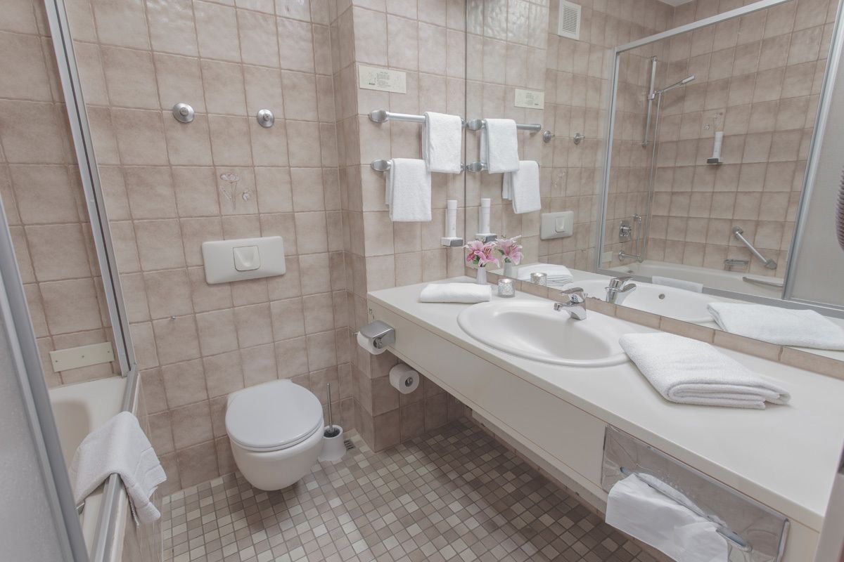 A modern bathroom with a toilet, sink, and shower area.