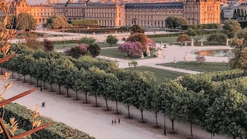 Vista del patio del Museo del Louvre con un edificio grande al fondo.