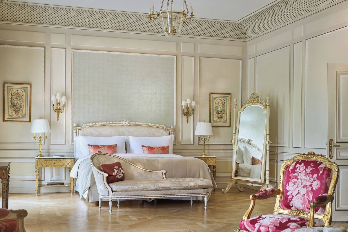 A luxurious bedroom with a large bed, ornate furniture, and classic decor.