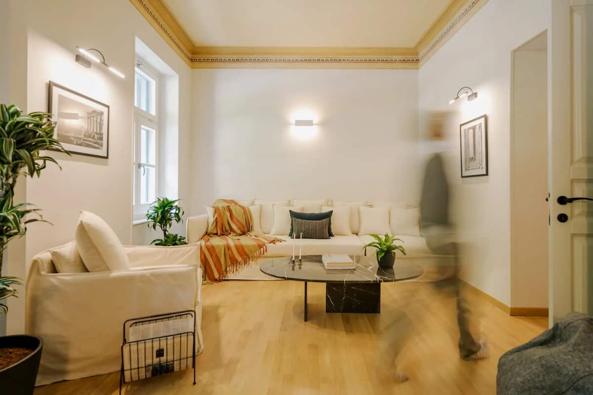 Un salon avec un canapé, un fauteuil, une table basse et des plantes en pot.