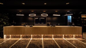 A reception desk with a marble floor, overhead lighting, and a plant to the left. - Mercure Antwerp City South (Antwerp)