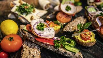 Una variedad de aperitivos en un plato, incluyendo pan con diferentes ingredientes y adornos.