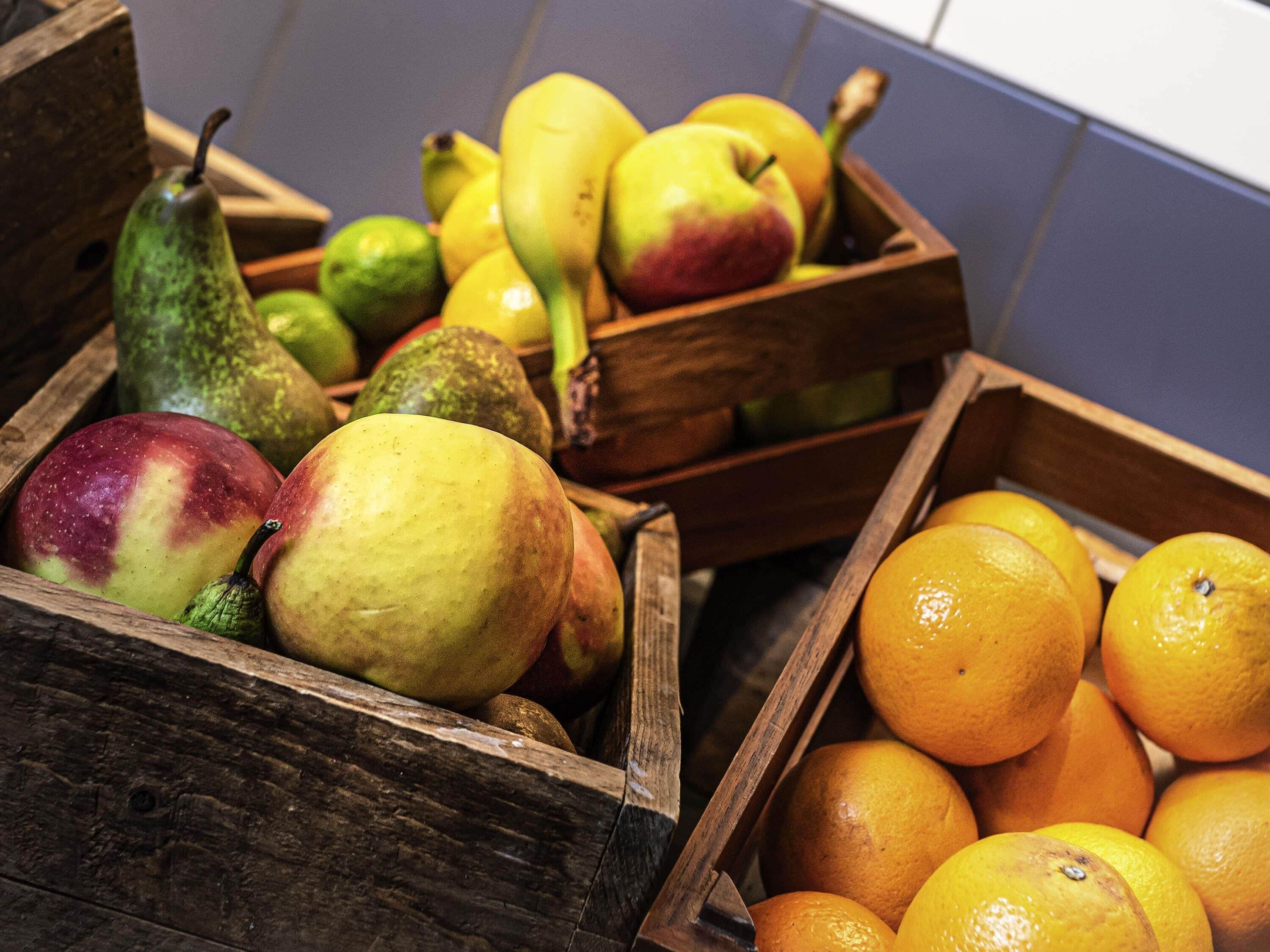 Wooden crates filled with various fruits including apples, pears, and oranges.