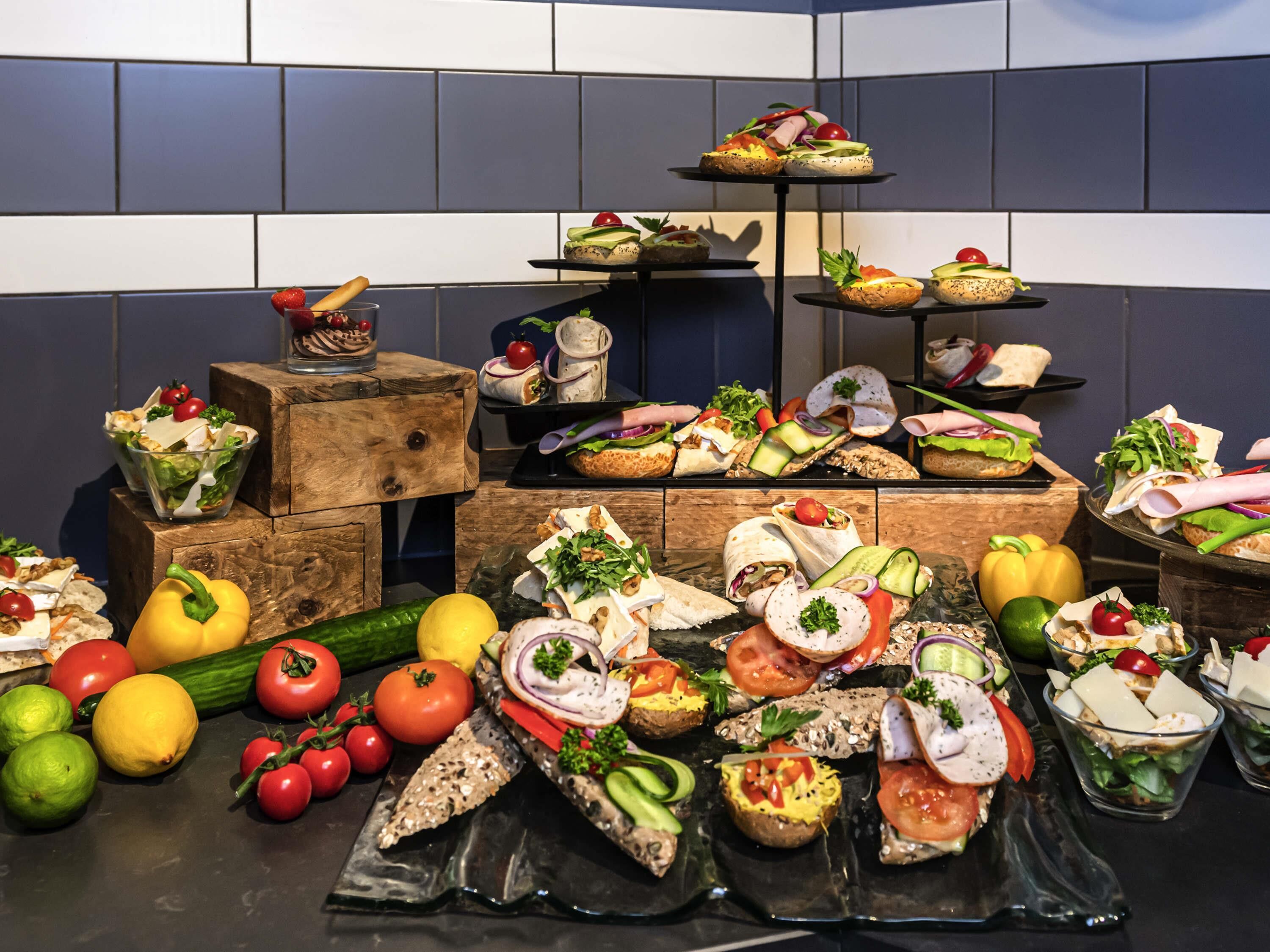 A buffet with various food items and fresh vegetables.