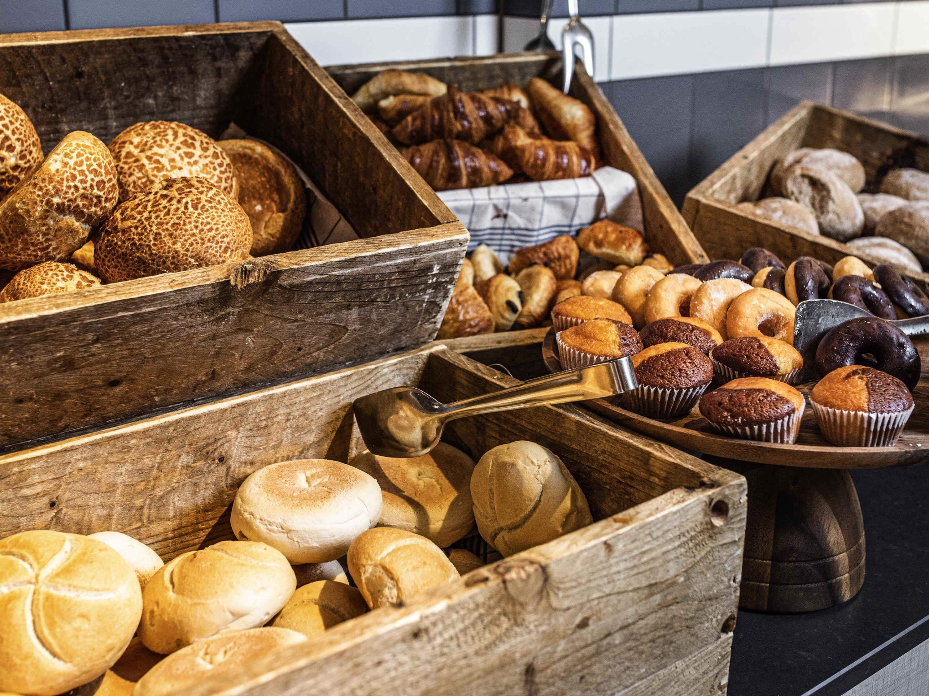 A variety of baked goods displayed in wooden containers.