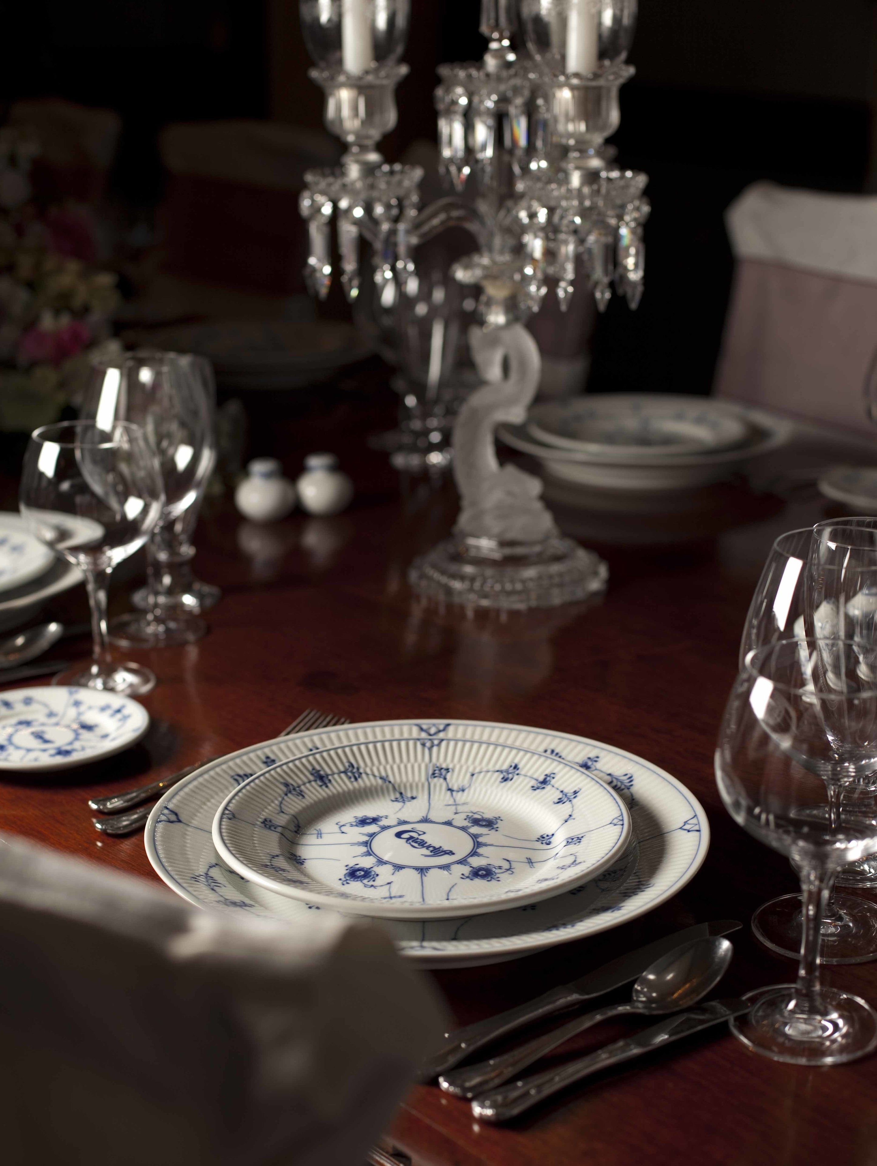 A dining table set with plates, glasses, and cutlery.