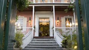 A staircase leading to a porch with white railings and potted plants. - Graycliff Hotel And Restaurant (Nassau)