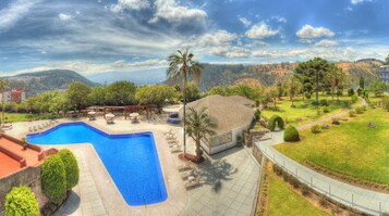 Una piscina al aire libre, sillones reclinables de piscina
