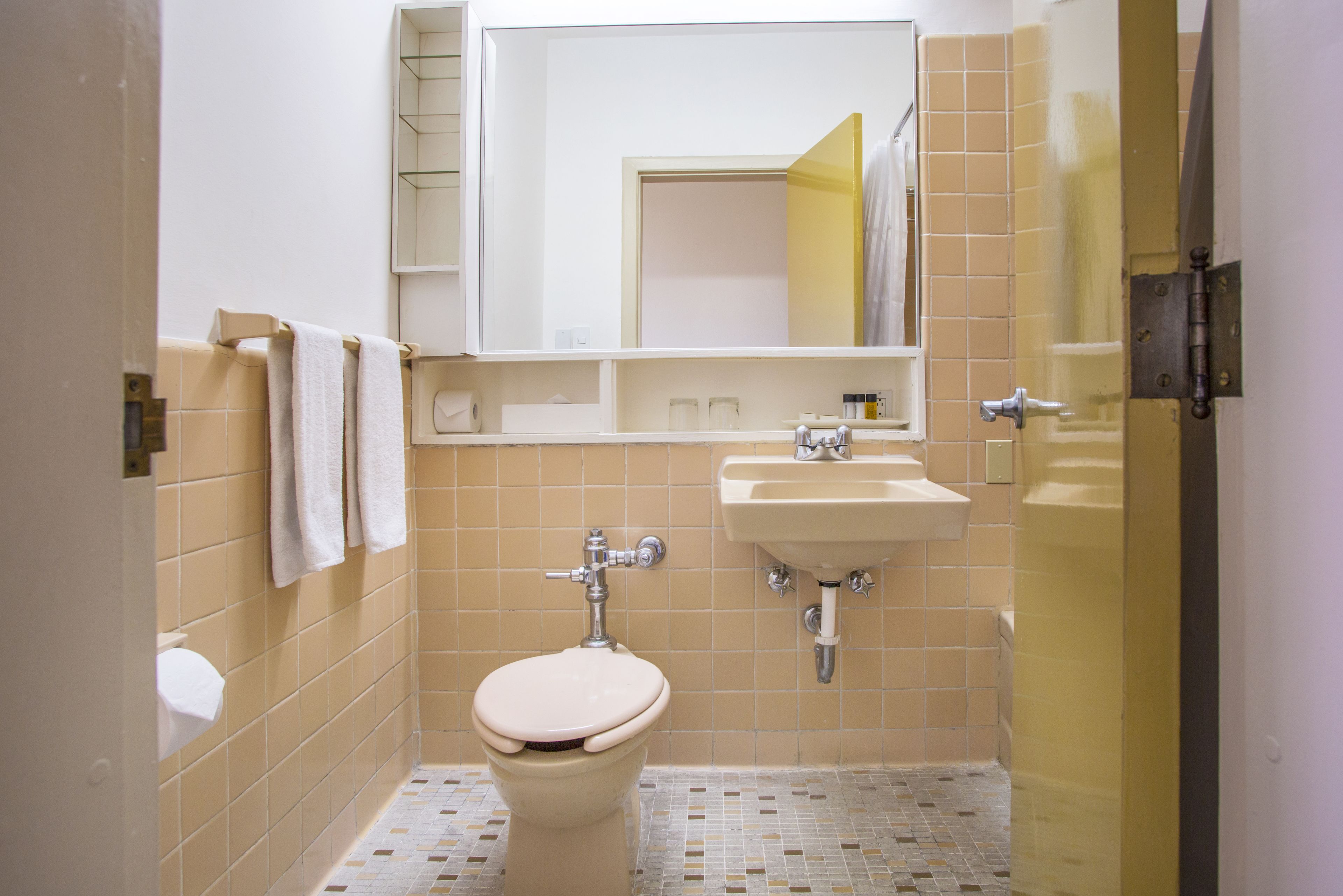 A small bathroom with a toilet, sink, and mirror.
