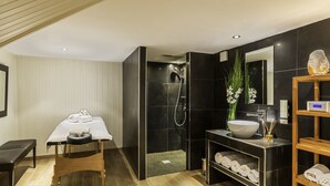A modern bathroom with a black and white color scheme, a wooden bench, a sink, and a shower area. - Best Western Plus Hotel Villa D'est (Strasbourg)