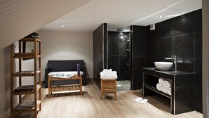 A modern bathroom with a black sink, a shower, and a wooden shelf with towels. - Best Western Plus Hotel Villa D'est (Strasbourg)