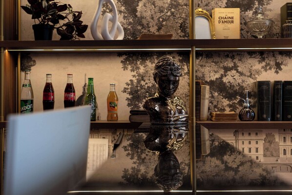 Una estantería con diversos objetos, como libros, botellas y una escultura.