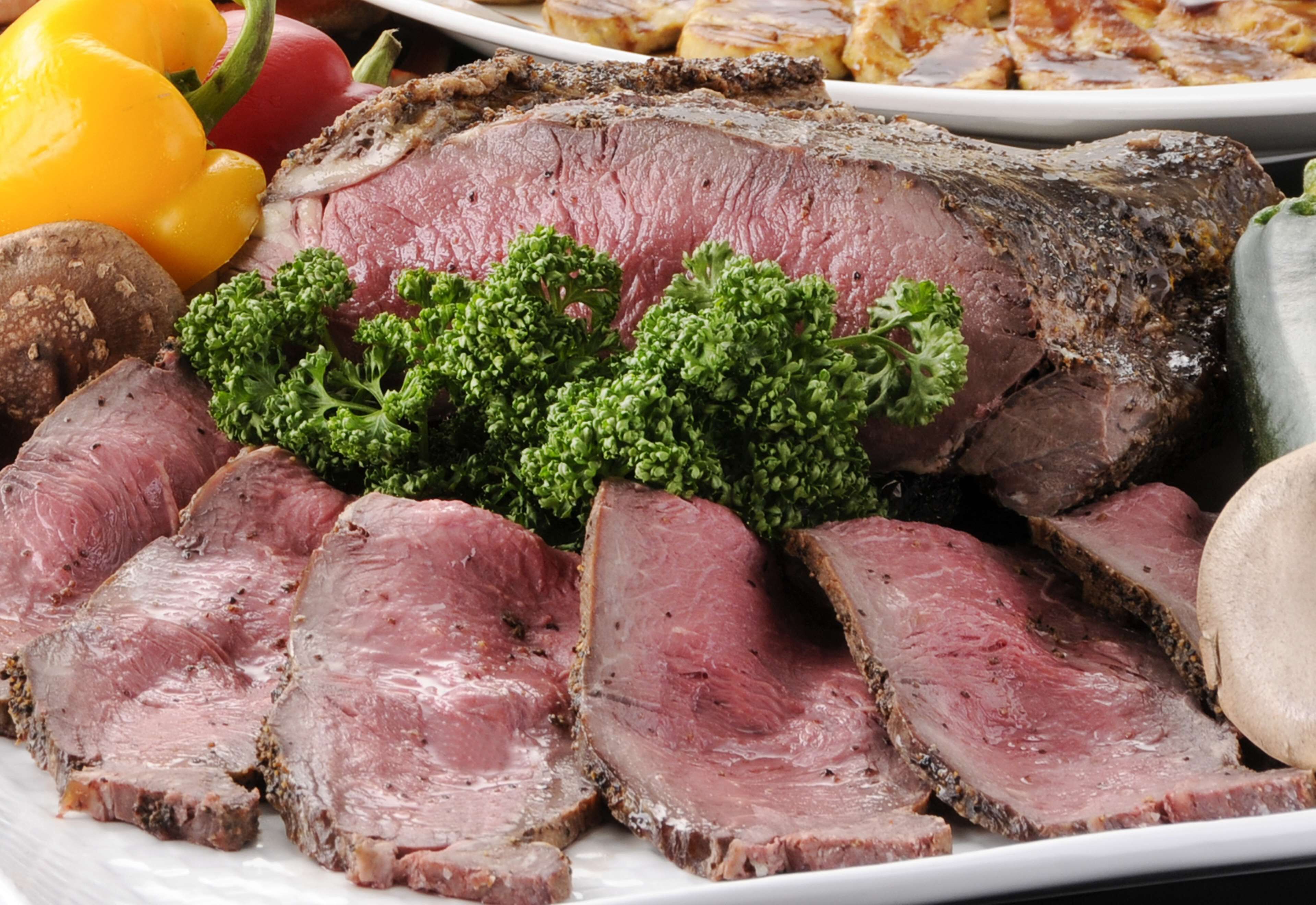 Une assiette de tranches de bœuf rôti, garnie de persil.