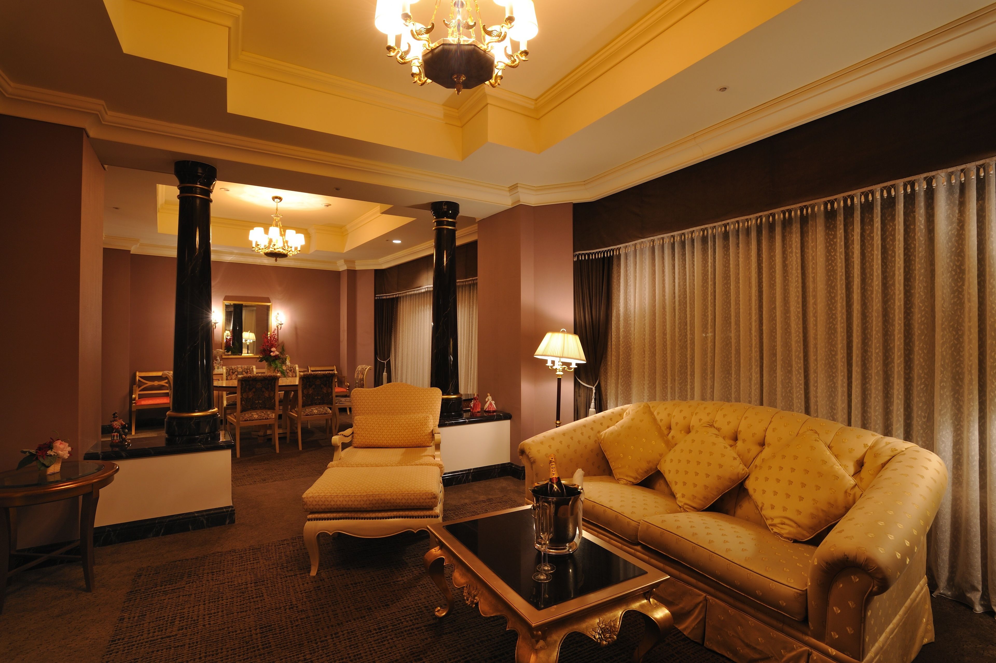 A well-appointed living room with a plush sofa, a coffee table, and a dining area with chairs and a table.
