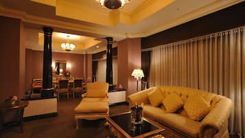 A well-appointed living room with a plush sofa, a coffee table, and a dining area with chairs and a table.