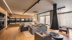 Una sala de estar moderna con chimenea, sofás y una estantería.