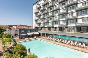 Una piscina al aire libre de temporada, sombrillas